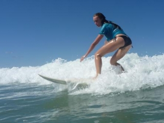 Alumno cogiendo una ola 